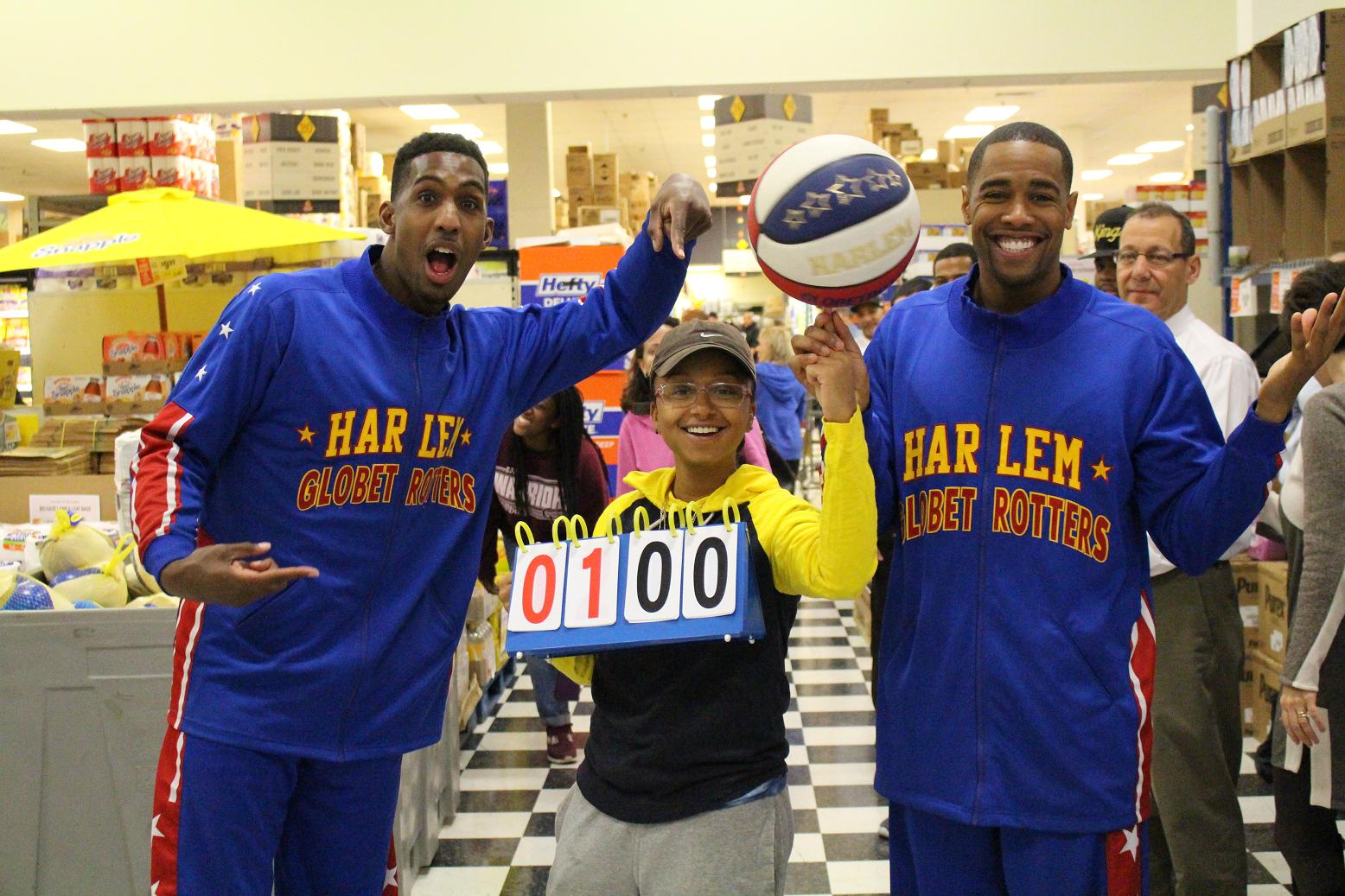 Bull Bullard (L), and Cheese Chisholm (R), guards for the world famous Harlem Globetrotters, celebrate with Yaritza Huertas, who scored the 100th basket at ShopRite’s second annual “Fowl” Shots for Food Banks.
